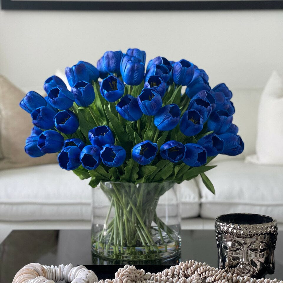Arrangement of blue tulips in a large cylindrical vase The New Garden 