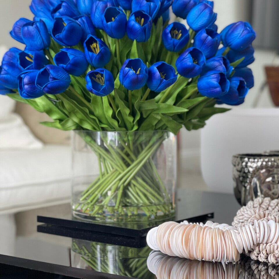 Arrangement of blue tulips in a large cylindrical vase The New Garden 